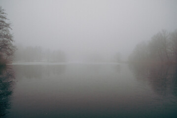 Obraz na płótnie Canvas lake with forest in the background, big fog