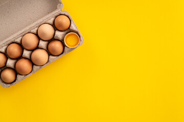 Fresh brown chicken eggs isolated on yellow table background.