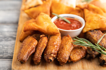 set of snacks: nachos, chicken wings, fried ribs, bean tortillas. Side view, selective focus.