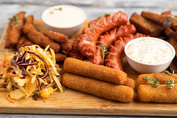 set of snacks: sausages, nuggets, cheese sticks, toast, cabbage salad. Side view, selective focus.