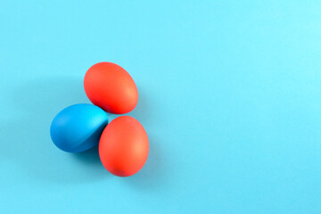 painted in red and blue easter eggs on sky blue background, close-up