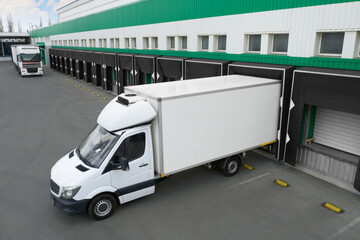 Trucks near big warehouse outdoors. Logistics center