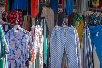 23 March 2022,  Leiden, Netherlands,  Women fashion, colorful clothes hanging on outdoor street market in the sunny day