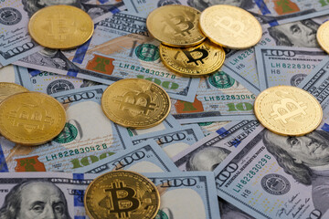 yellow bitcoin coins scattered over US dollar paper banknotes