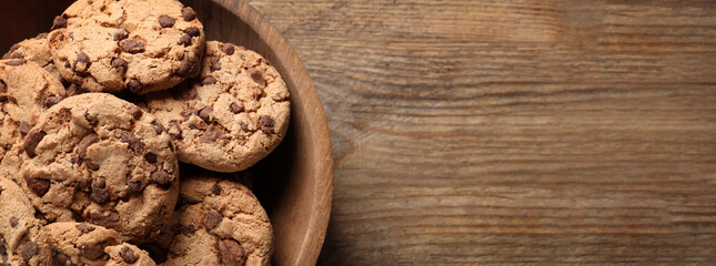 Delicious chocolate chip cookies on wooden table, top view with space for text. Banner design