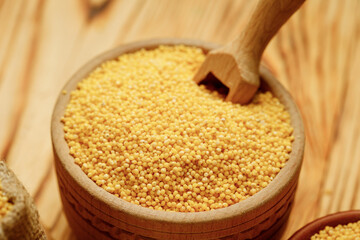Millet polished in bowls and bags on a wooden background. High quality photo