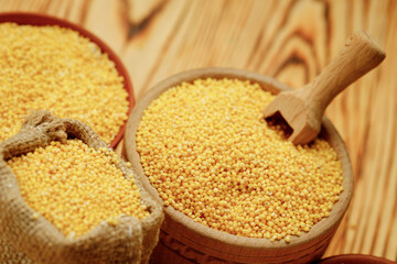 Millet polished in bowls and bags on a wooden background. High quality photo