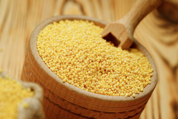 Millet polished in bowls and bags on a wooden background. High quality photo