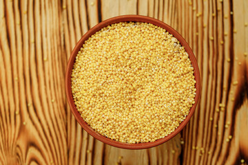 Millet polished in bowls and bags on a wooden background. High quality photo