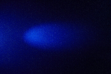 On a dark blue gradient background, a blue cloud of light