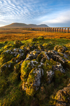 Beautiful ripple clouds in sky above Ribblehead Viaduct in the Yorkshire Dales National Park, UK. Soft morning light can be seen illuminating the rocks in foreground.