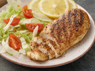 Fried chicken breast. Grilled chicken breast with vegetable salad and lemon