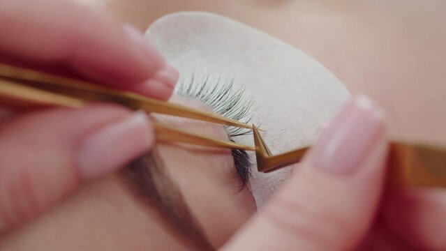 The master performs the procedure of eyelash extensions