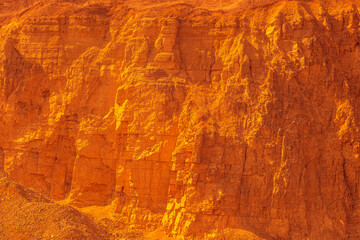 Orange canyon wall of a rock at a quarry.