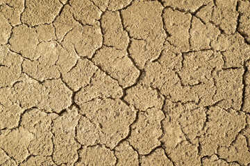 Sand dried cracked soil, textured.