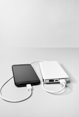 Smartphone is connected with a usb cable and is charged from the power bank battery