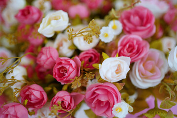 Decorative plastic flowers on pink background.