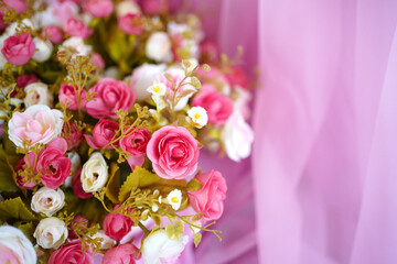 Decorative plastic flowers on pink background.
