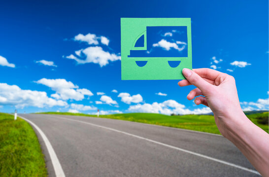 Hand Holds Green Logistics Symbol On Street In The Nature Background.