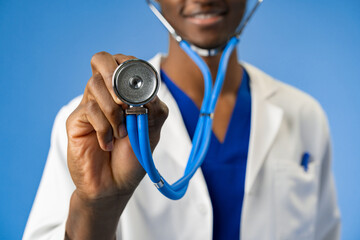 Cropped photo of black medical doctor with stethoscope on blue