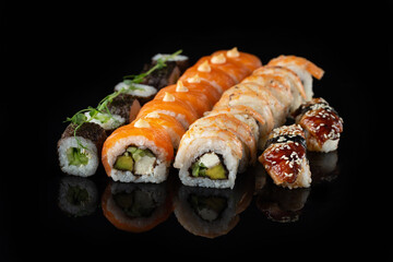 Traditional delicious fresh sushi roll set on a black background with reflection. Sushi roll with rice, nori, cream cheese, tobiko caviar, avocado. Sushi menu. Japanese kitchen. Asian food