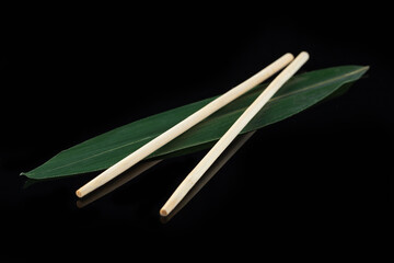 Sushi sticks on a banana leaf on a black background with reflection. Sushi menu. Japanese kitchen, restaurant.