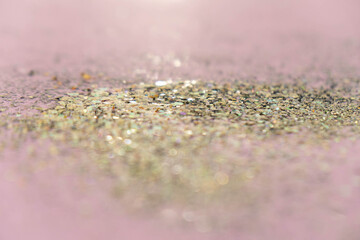 Gold sequins on pastel pink background. Festive concept.Selective focus.