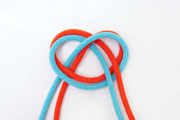 Heart symbol made of two colored cords on gray