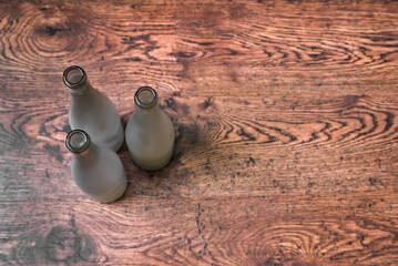 Top view of empty glass wine bottles standing on wooden floor