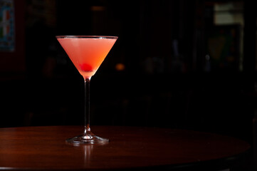 cosmopolitan cocktail on wooden table and dark background