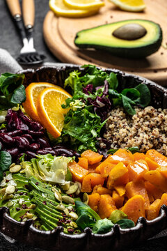 Quinoa salad in bowl with avocado, sweet potato, beans on gray background. superfood concept. Healthy, clean eating concept. Vegan or gluten free diet. vertical image. top view