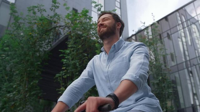 Portrait handsome man riding bicycle at downtown district. Alternative transport