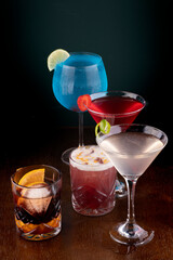 mixology - colorful cocktails collection on wooden table.