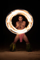Polynesian male Fire dancer performing with spinning flame - obrazy, fototapety, plakaty
