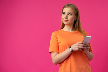 Portrait of a young woman using mobile phone over color background.