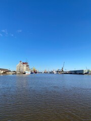 Obraz na płótnie Canvas Russia, Kaliningrad, hoisting cranes in the commercial port. Ship at the pier.