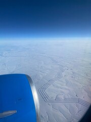 airplane wing above earth. Photos from the windows of the plane that are going to Airport. lines on the ground from an airplane
