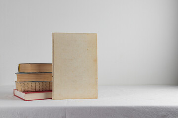 Stack of old rustic vintage books on white table 