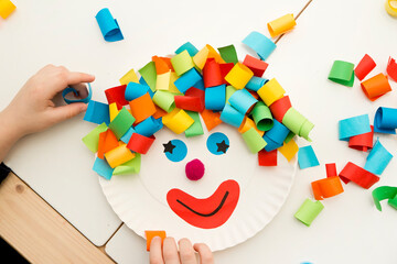 Paper plate clown. DIY games at home, activities for pre-school Kids. 5 minute crafts. Children joy and funny to cut a hair for clown. Red Nose Day theme.