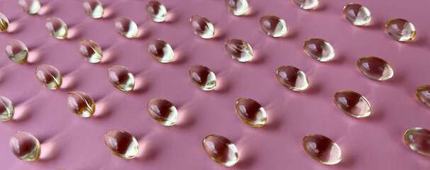 Vitamin E capsules pattern pink background 