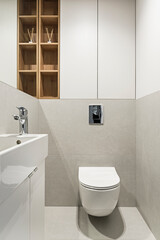 Fototapeta na wymiar Jasna łazienka z umywalką, baterią, lustrem. Toaleta w mieszkaniu