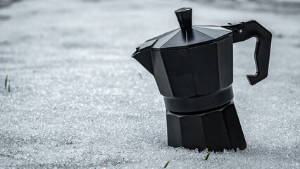 Black moka pot in snow 