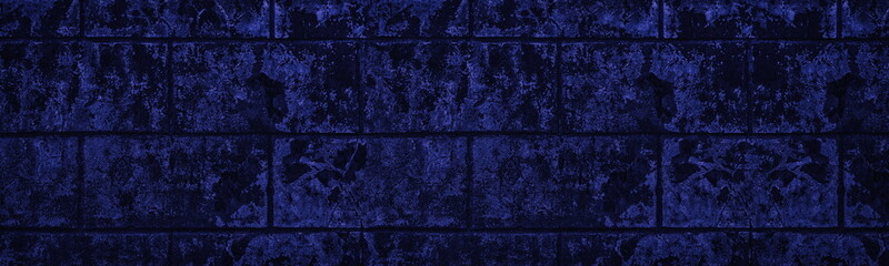 Navy blue old concrete block wall with shabby peeling paint wide texture. Indigo gloomy grunge long backdrop. Dark large sinister abstract background