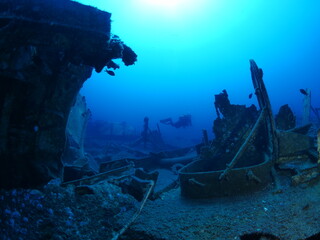 scuba divers exploring shipwreck scenery underwater ship wreck deep blue water ocean scenery of metal underwater