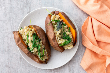 Baked in skin sweet potato with quinoa and lettuce close-up on a plate, vegetarian food
