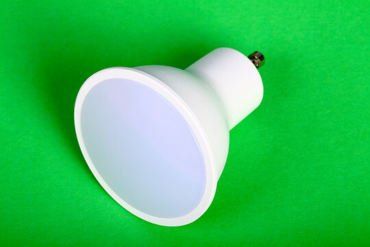 One energy saving GU10 led bulb isolated on a green background