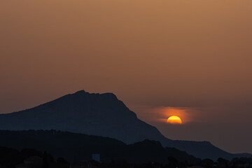 the Sainte Victoire mountain in the light of a hazy spring sunrise