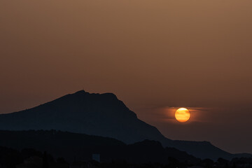 the Sainte Victoire mountain in the light of a hazy spring sunrise