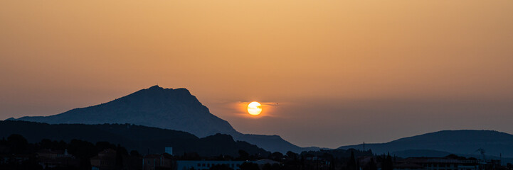 the Sainte Victoire mountain in the light of a hazy spring sunrise