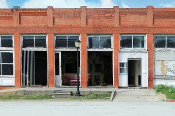 small town rural abandoned old vandalized brick building downtown shops wreck damaged storefront